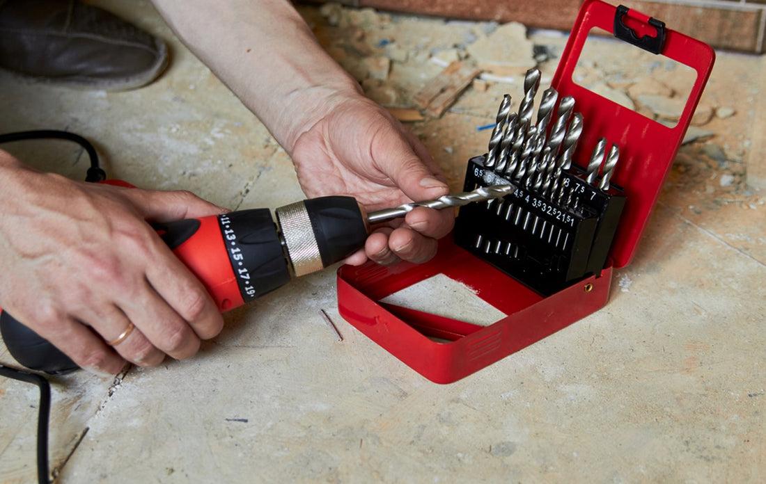 Man putting new drill bit into electric drill