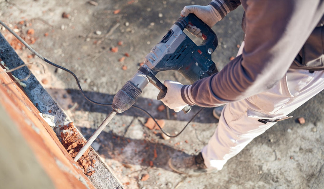 Man working on house with large masonry drill bit