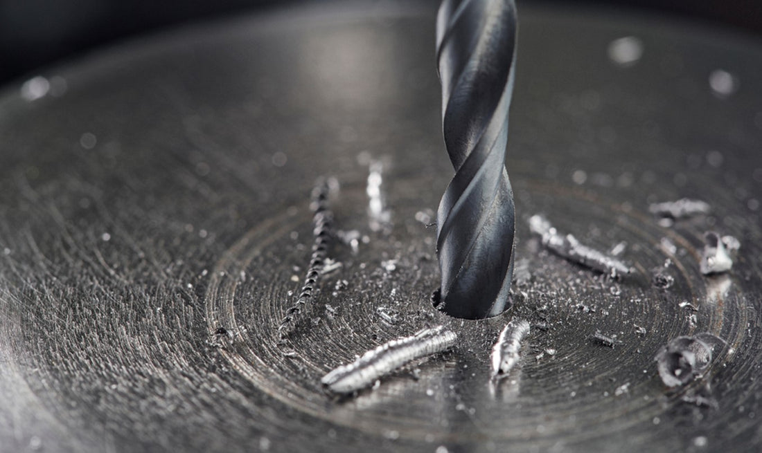 Metal drill bit making hole in stainless steel