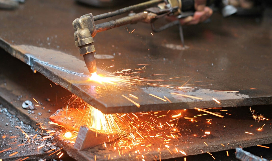 Gas torch cutting sheet of metal and producing sparks