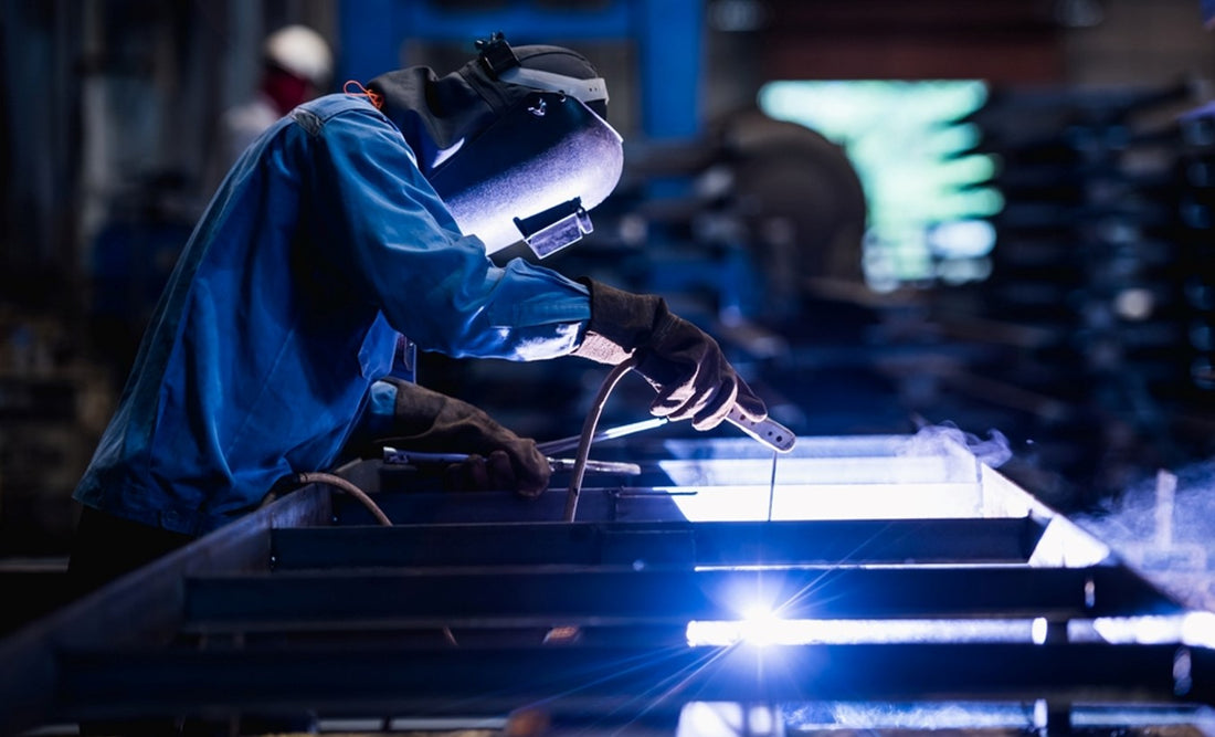 Industrial welder doing SMAW welding in factory
