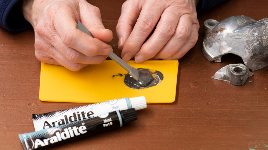 Man spreading Araldite adhesive on yellow plastic with spatula