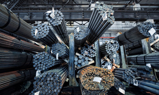 Rolls of metal pipes and bars stacked in warehouse 