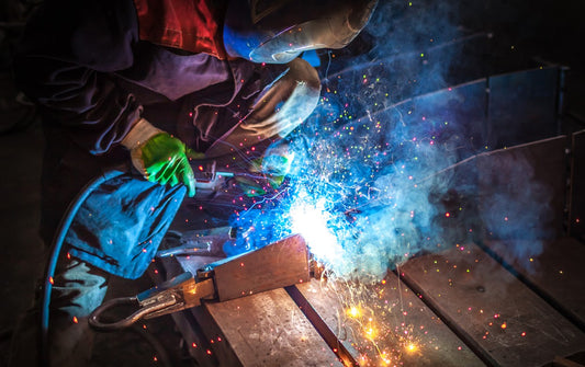 Welder in shop doing MIG welding