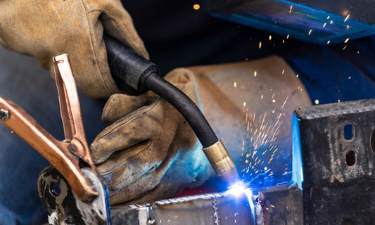 Welder uses MIG welding to join two pieces of metal