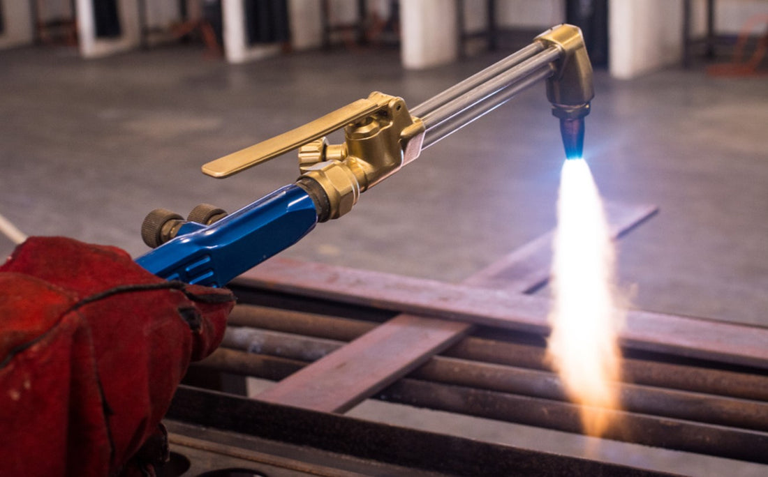Welder using an acetylene gas cutting torch to cut metal