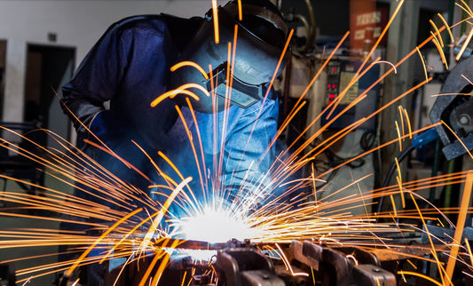 welder using bronze brazing rod in machine shop while wearing PPE