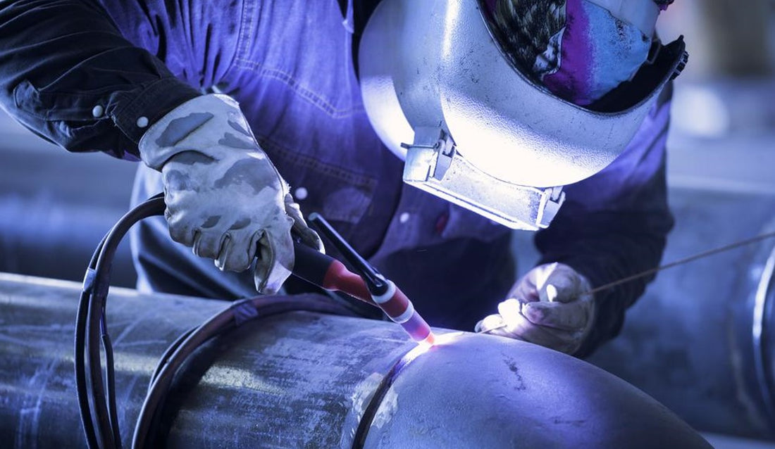 welder working on metal piping using TIG welding