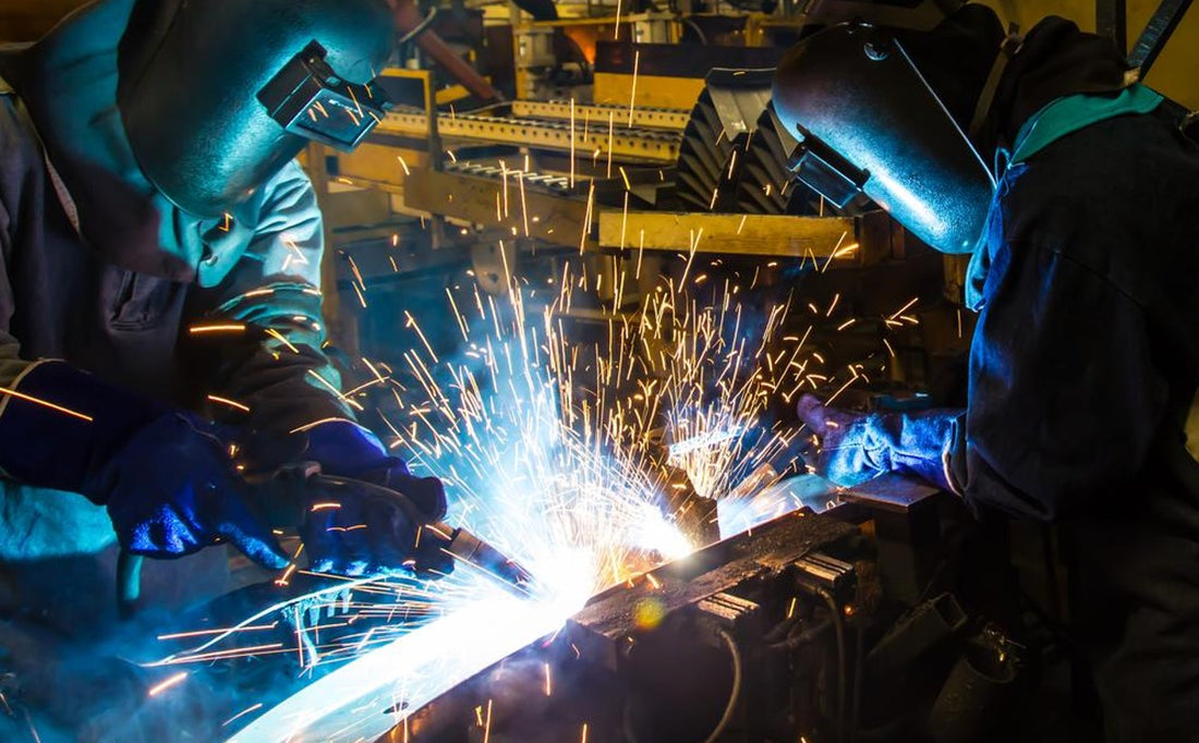 welders welding in an industrial automotive factory