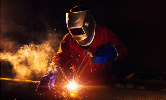 welding in dark room with sparks and smoke in air